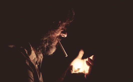 A man lighting a cigarette